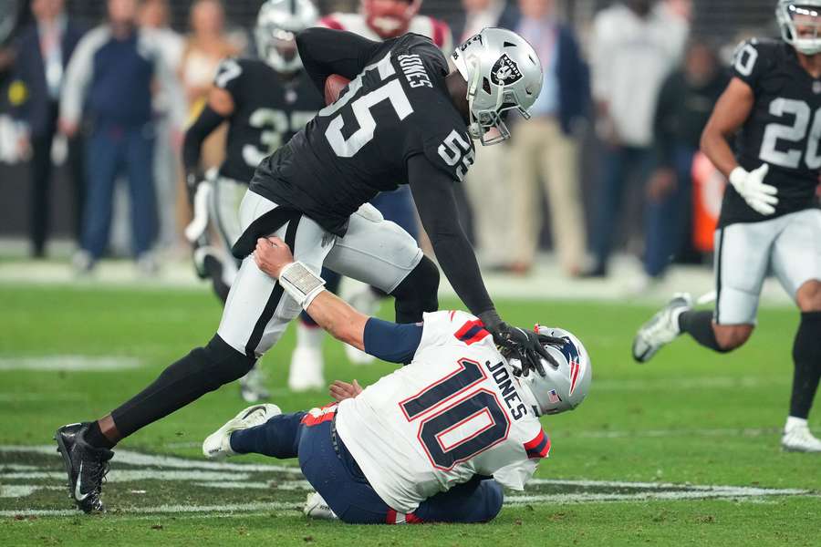 Las Vegas Raiders defensive end Chandler Jones (55) stiff-arms New England Patriots quarterback Mac Jones (10)