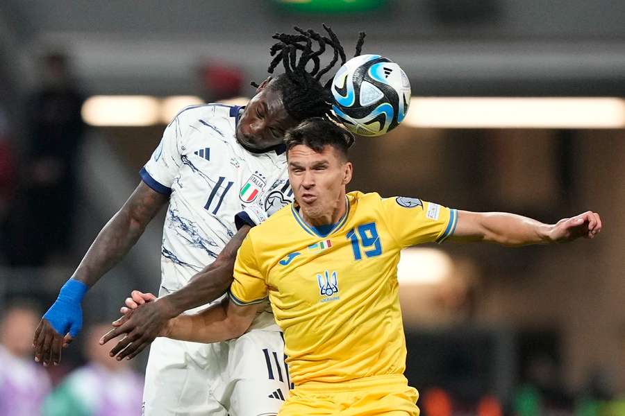 Italy's Moise Kean jumps for a header with Ukraine's Oleksandr Tymchyk during their qualifier