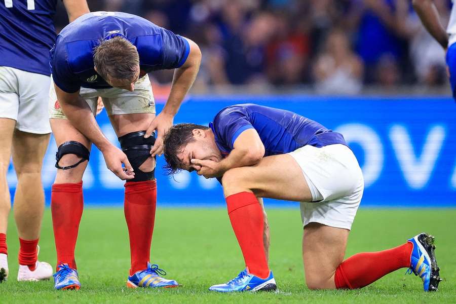 Antoine Dupont clutches his face after the tackle from Johan Deysel