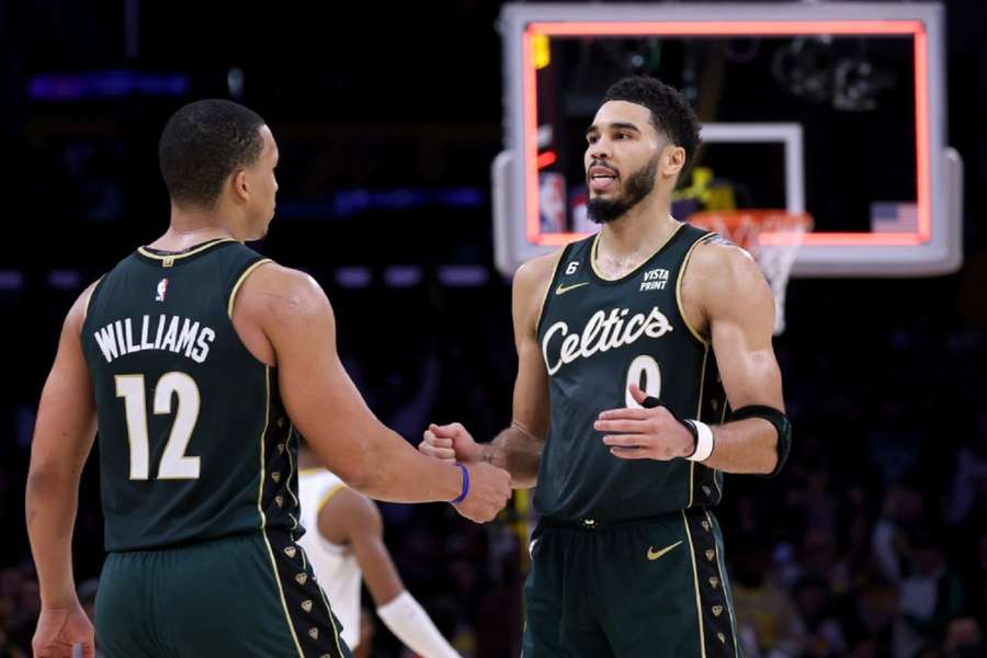 Jayson Tatum (0) en Grant Williams (12) vieren de overwinning in overtime tijdens de buzzer