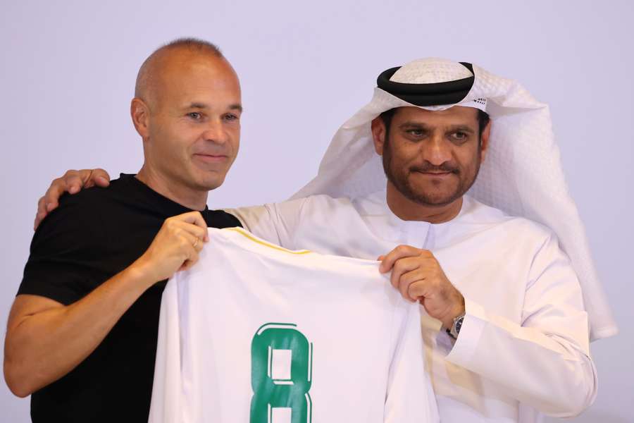Iniesta pózuje so svojím novým dresom po boku predsedu klubu Emirates Youssefa Abdullaha al-Batrana.