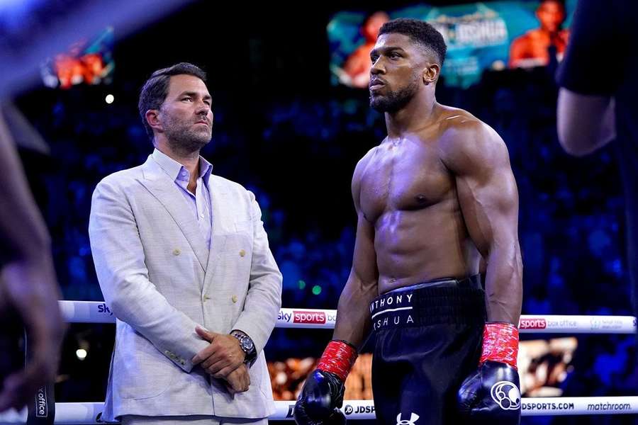 Eddie Hearn (L) stands next to Anthony Joshua (R) in the ring