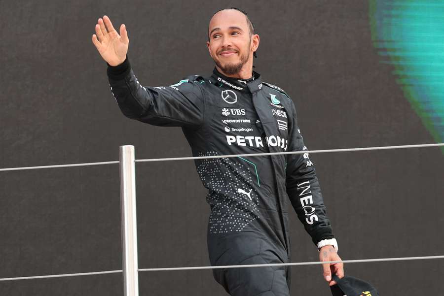 Mercedes' Lewis Hamilton waves from the podium after his third-place finish at the Spanish Grand Prix