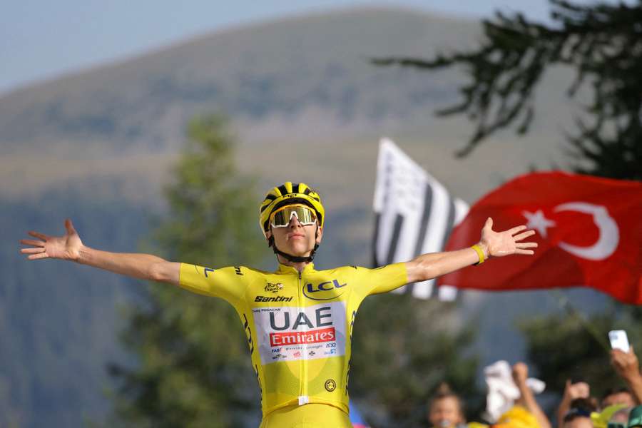 Tadej Pogacar celebrates as he crosses the finish line