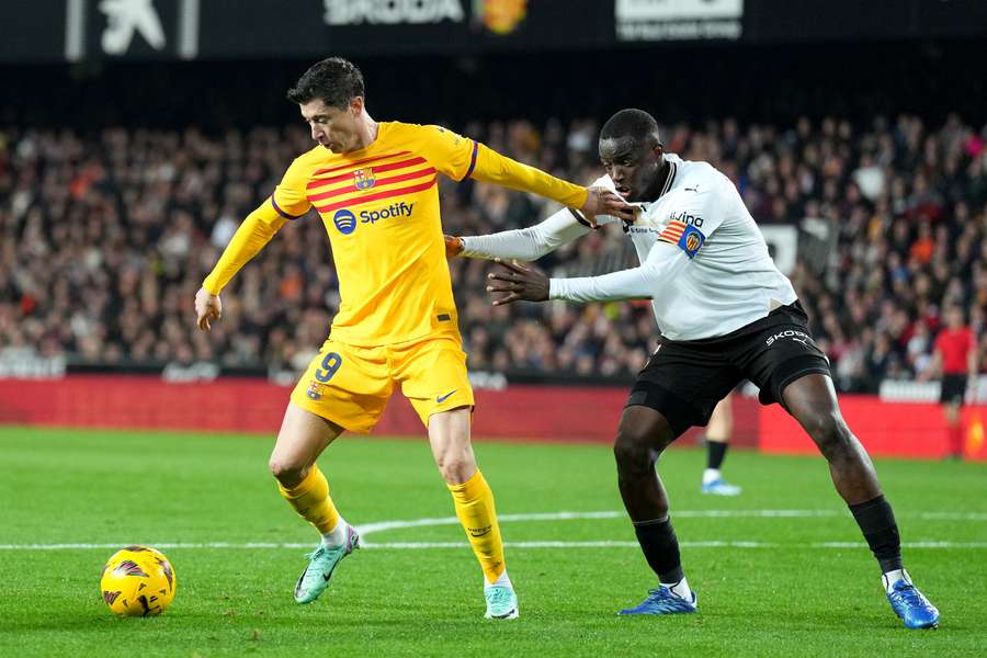 Robert Lewandowski of FC Barcelona controls the ball whilst under pressure from Mouctar Diakhaby of Valencia