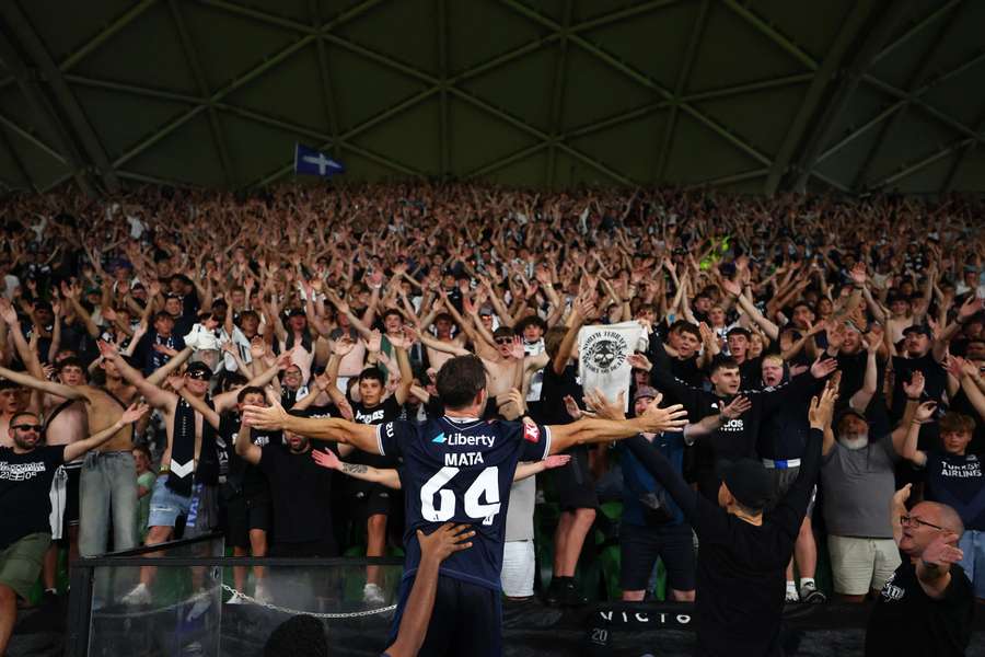 Juan Mata leads the celebrations with Melbourne Victory fans on Saturday.