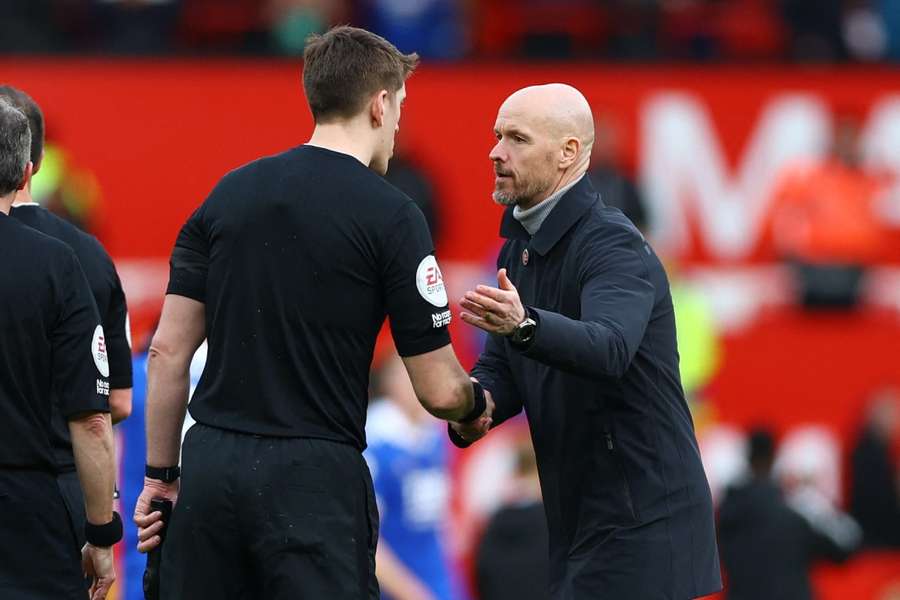 Manchester United manager Erik ten Hag shakes hands with the assistant referee