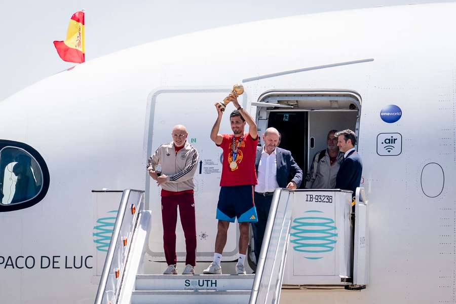 Rodri holds the World Cup aloft after arriving back in Spain