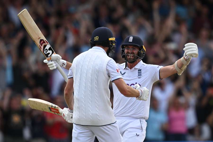 England's Mark Wood (R) runs to celebrate with England's Chris Woakes (L) after Woakes hits a boundary to win the test match