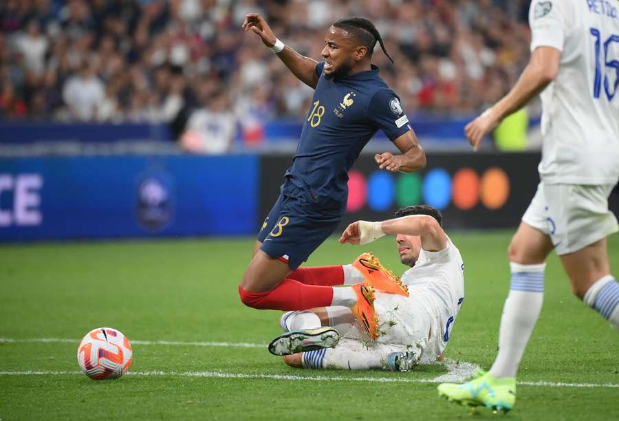 France's forward Christopher Nkunku (L) is tackled by Greece's midfielder Dimitrios Kourbelis during the UEFA Euro 2024 group B qualification football match between France and Greece