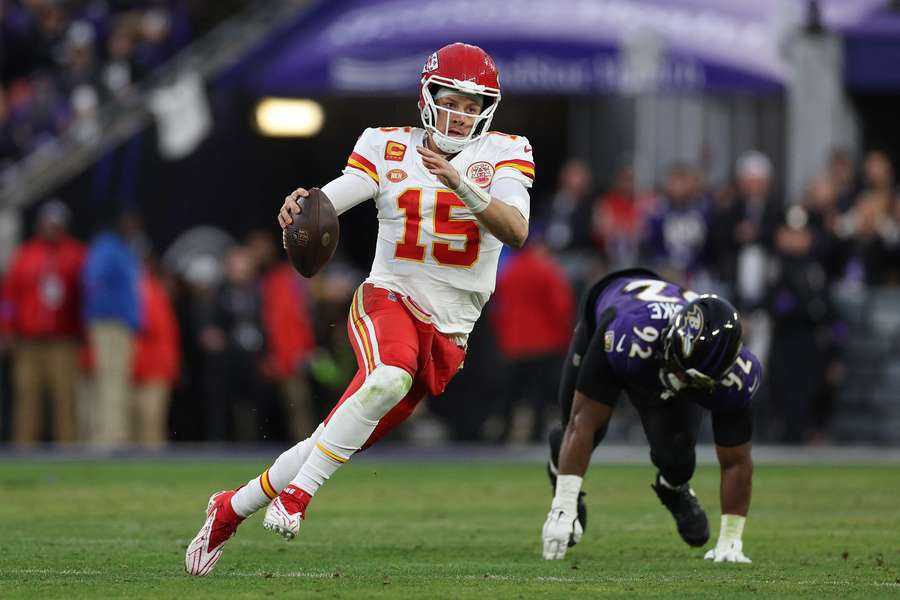 Patrick Mahomes of the Kansas City Chiefs scrambles under pressure from Justin Madubuike of the Baltimore Ravens