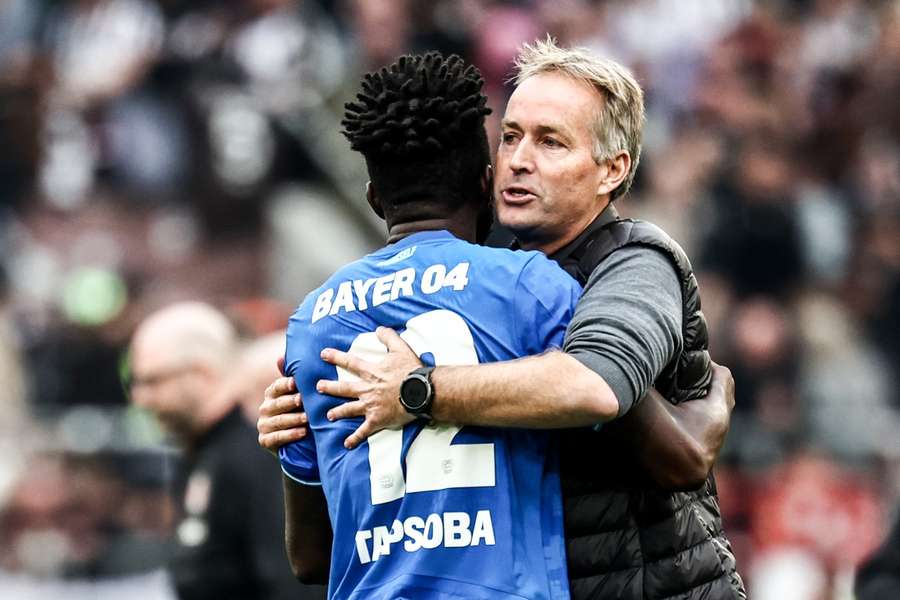 Leverkusen head coach Kasper Hjulmand (R) celebrates with player Edmond Tapsoba