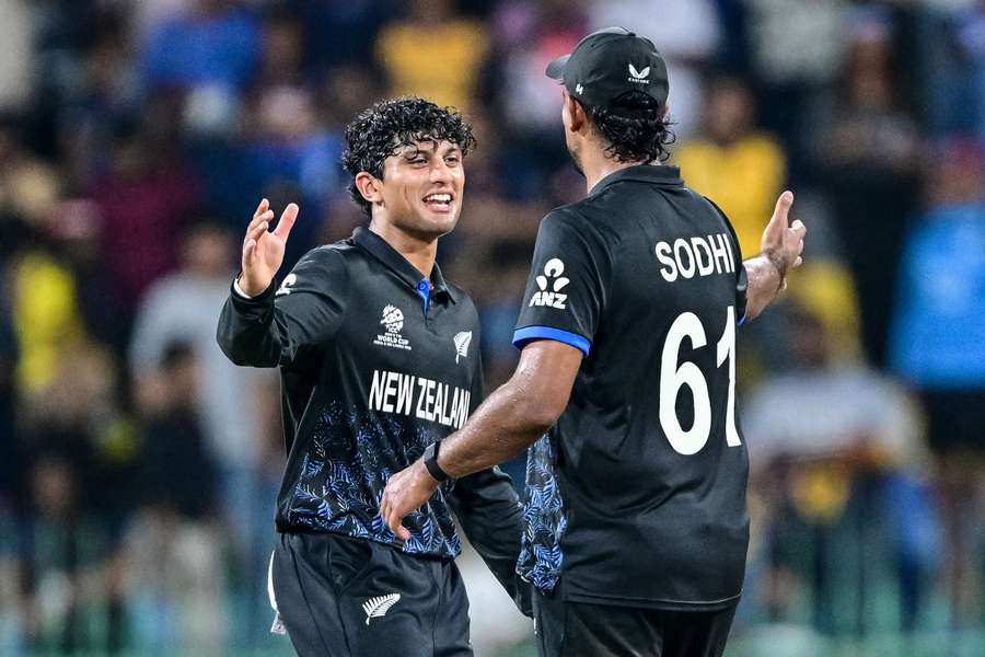 New Zealand's Rachin Ravindra (L) and teammate Ish Sodhi celebrate their team's win