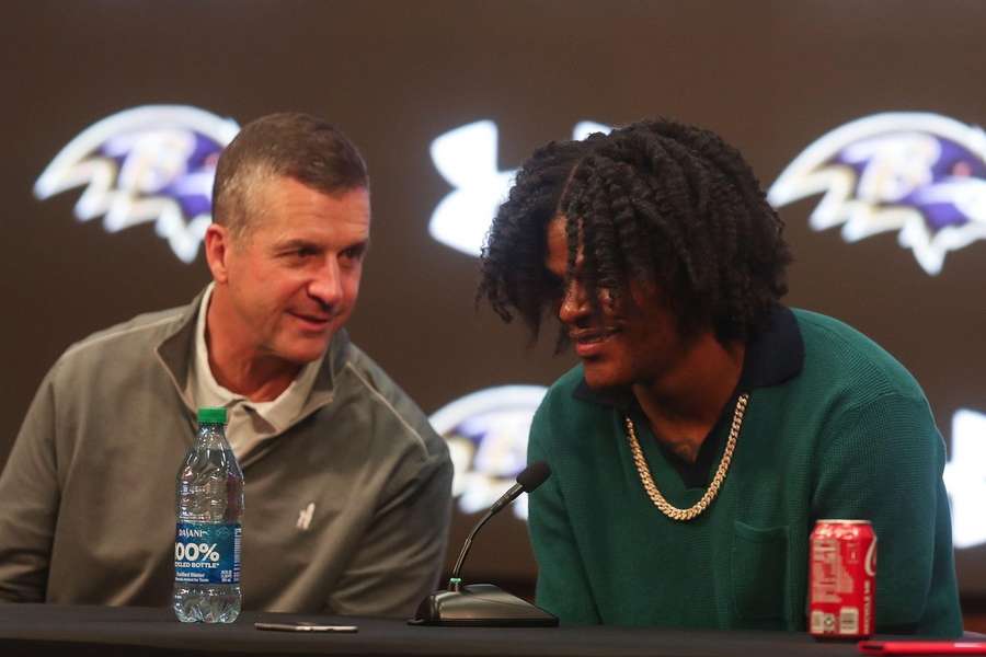 John Harbaugh (L) en Lamar Jackson tijdens een persconferentie vlak nadat bekend werd dat de quarterback bijtekende in Baltimore