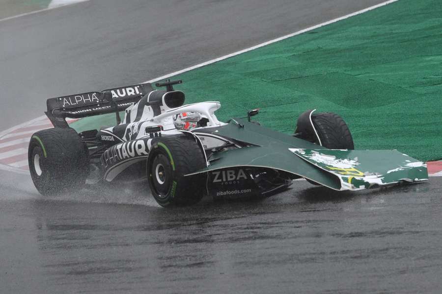 Some signage blows onto the front of the car of AlphaTauri's French driver Pierre Gasly during a stormy Formula One Japanese Grand Prix