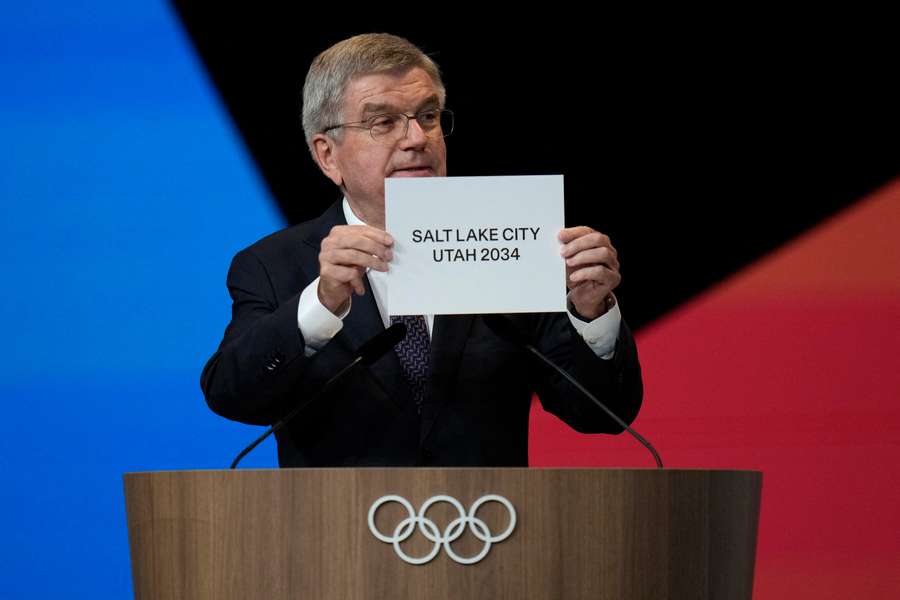 International Olympic Committee (IOC) president Thomas Bach shows a sign that Salt Lake City has been awarded to be the host of the 2034 Winter Games