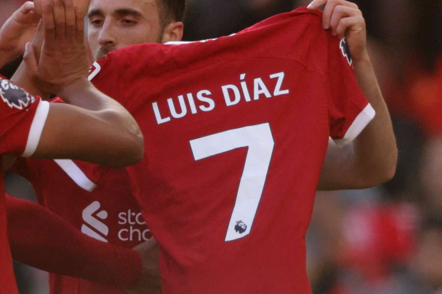 Diogo Jota holds up a Liverpool shirt with Luis Diaz's name on the back