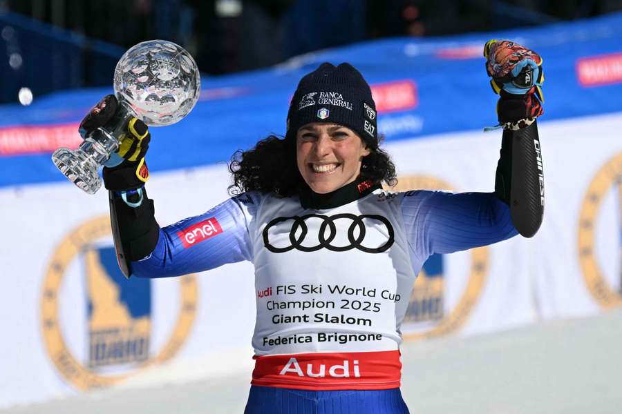 Italy's Federica Brignone celebrates with the crystal globe after winning the overall title during the women's Giant Slalom