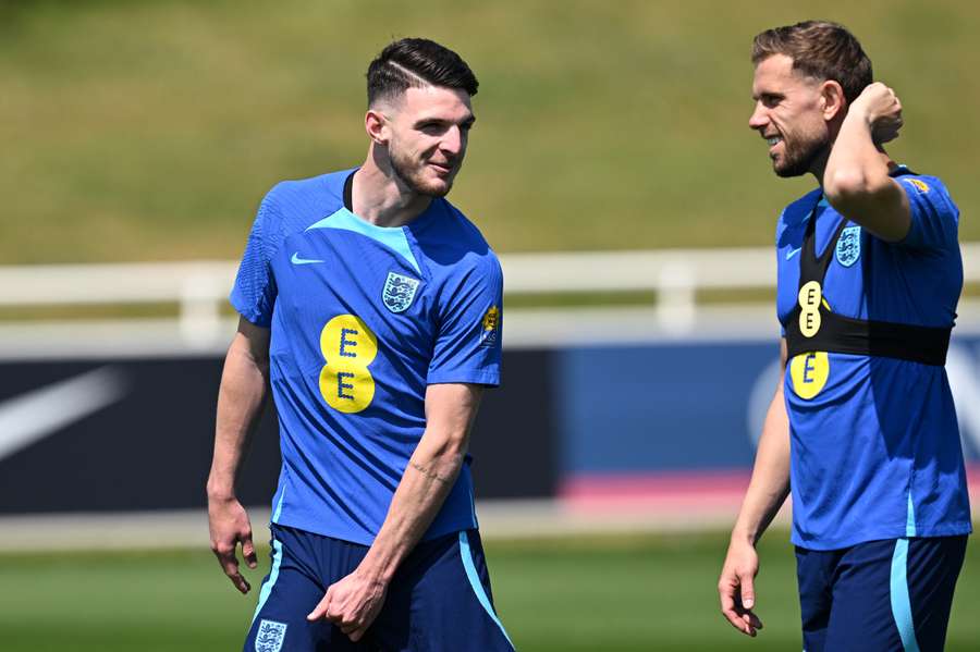 England's midfielder Declan Rice (L) speaks with England's midfielder Jordan Henderson during an England training session