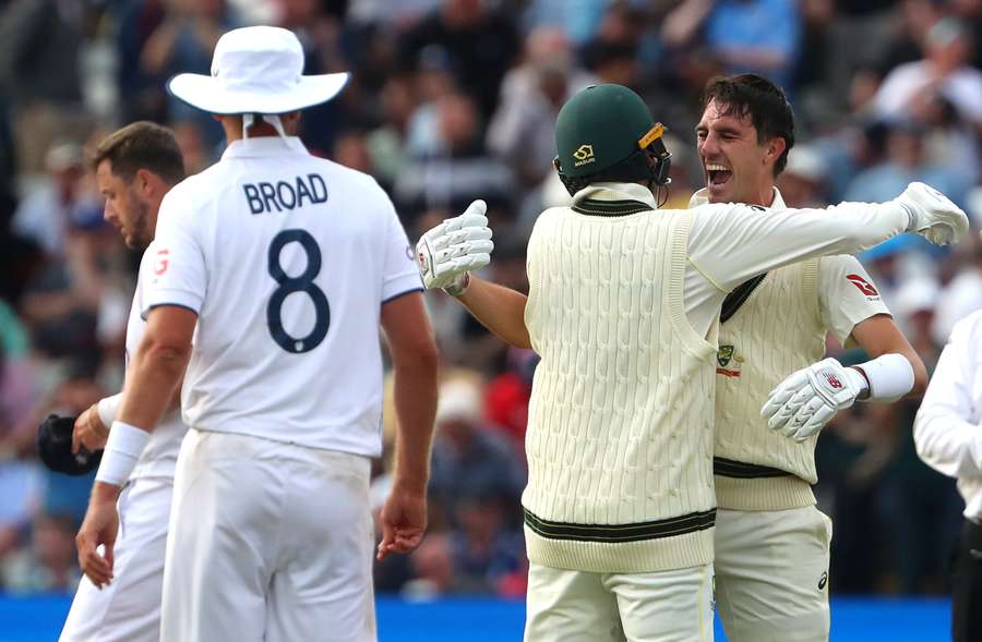 Australia's Pat Cummins (R) celebrates with Nathan Lyon after winning the first Ashes cricket Test match against England