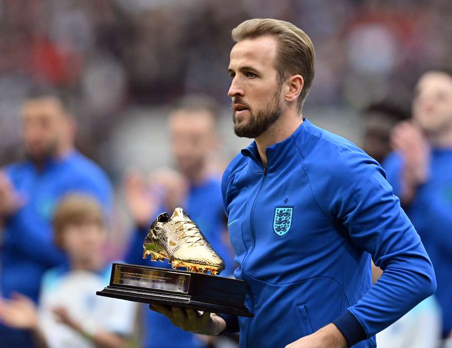 England's striker Harry Kane receives a golden boot trophy 