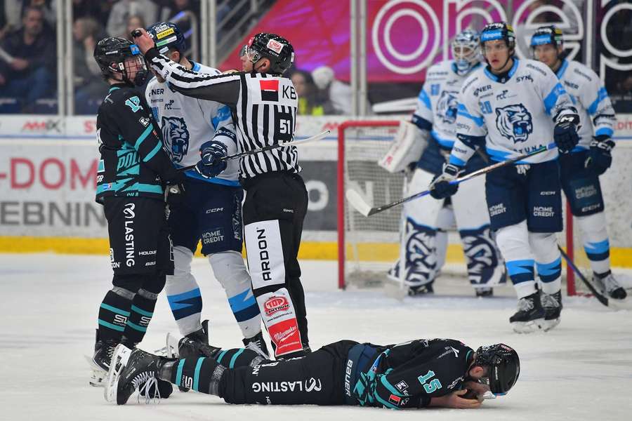 Petr Tomek leží po tvrdém zákroku v zápase s Libercem na ledě.