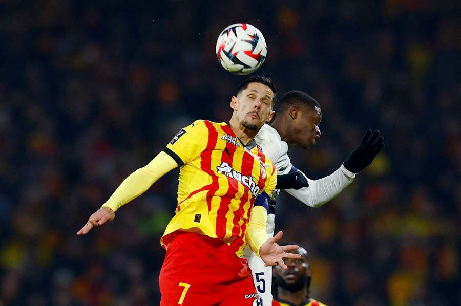 RC Lens' Florian Sotoca in action against PSG's Nuno Mendes