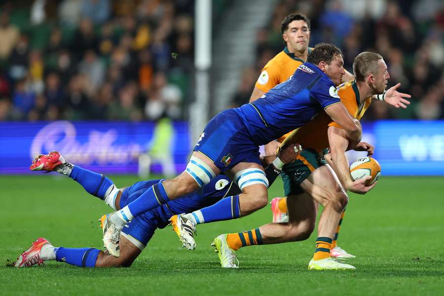 Italy's captain Michele Lamaro lays a tackle on Australia winger Harry Potter. Italy's captain Michele Lamaro lays a tackle on Australia winger Harry Potter.