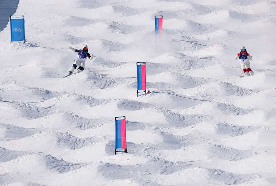Mikael Kingsbury do Canadá em ação com Takuya Shimakawa do Japão durante as meias-finais dos duplos moguls
