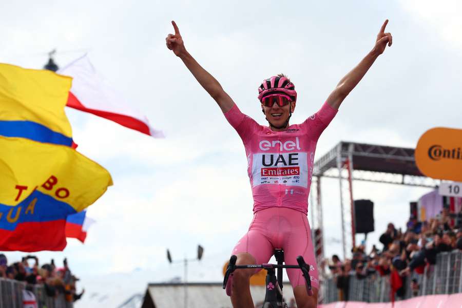 Tadej Pogacar celebrates as he crosses the finish line to win the 15th stage