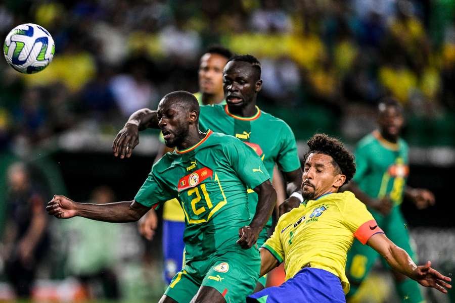 Youssouf Sabaly(l) en Marquinhos (r) in duel op de bal, Sadio Mane (m) kijkt toe