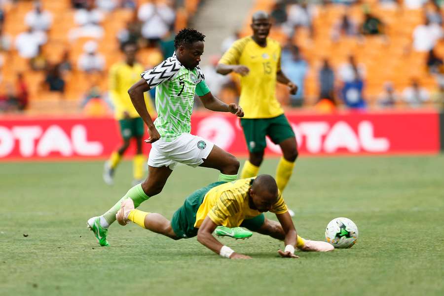 Tiyani Mabunda (R) is tackled by Nigeria's captain Ahmed Musa during an African Cup of Nations qualifier in 2018