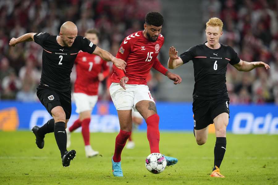 Gernot Trauner (L) en Nicolas Seiwald (R) proberen Philip Billing van Denemarken van de bal af te zetten in een wedstrijd juni 2022