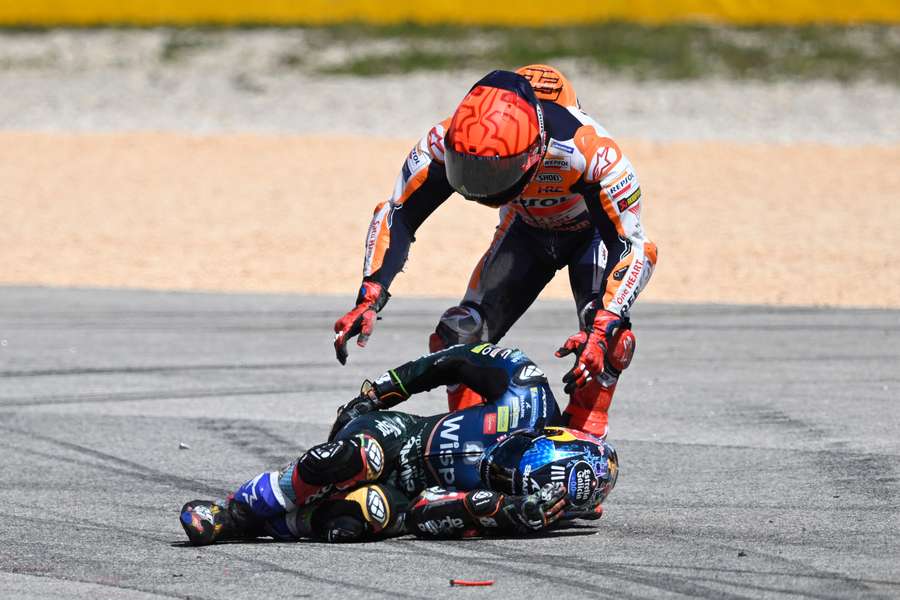 Honda Spanish rider Marc Marquez checks on Aprilia Portuguese rider Miguel Oliveira after crashing during the MotoGP race 