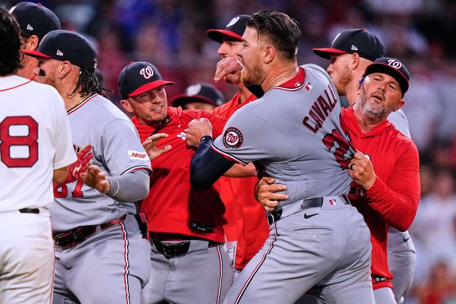 Washington Nationals players and coaches hold back Cade Cavalli