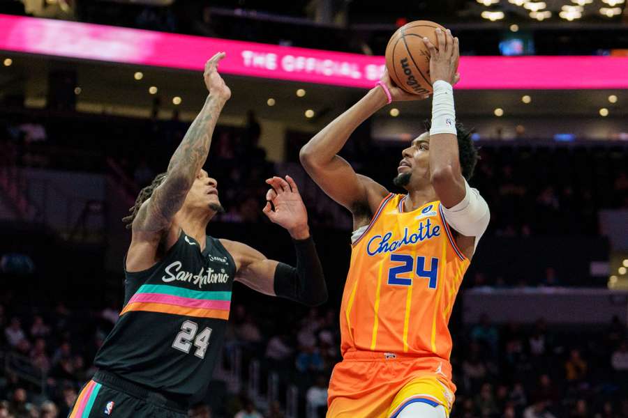 Brandon Miller of the Charlotte Hornets shoots the ball over Devin Vassell of the San Antonio Spurs