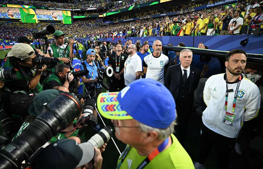 Na zdjęciu - trener Carlo Ancelotti oddzielony od zawodników ścianą fotoreporterów podczas hymnów Na zdjęciu - trener Carlo Ancelotti oddzielony od zawodników ścianą fotoreporterów podczas hymnów
