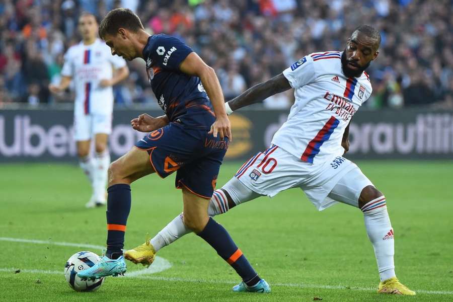 Alexandre Lacazette se snaží vydolovat balon v utkání s Montpellier.