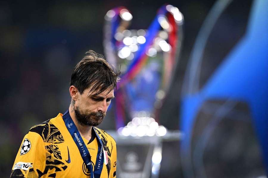 Francesco Acerbi looks dejected as he walks past the Champions League trophy after defeat to PSG