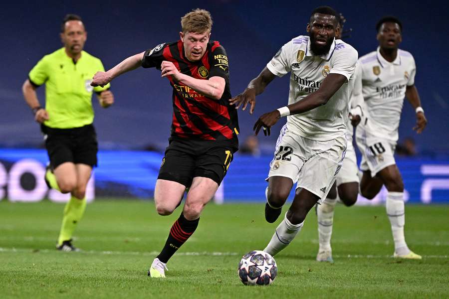 El centrocampista del Manchester City Kevin De Bruyne (L) compite con el defensa del Real Madrid Antonio Rudiger