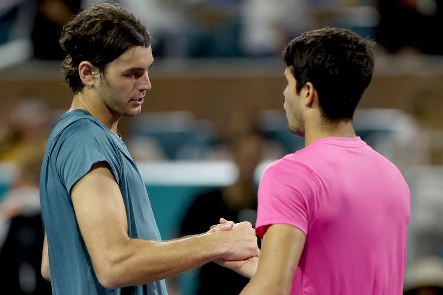 Taylor Fritz (L) shakes hands with Carlos Alcaraz