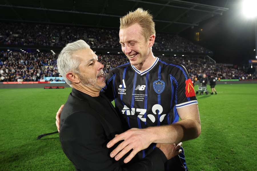 Auckland head coach Steve Corica embraces star player Francis de Vries after their Grand Final win.