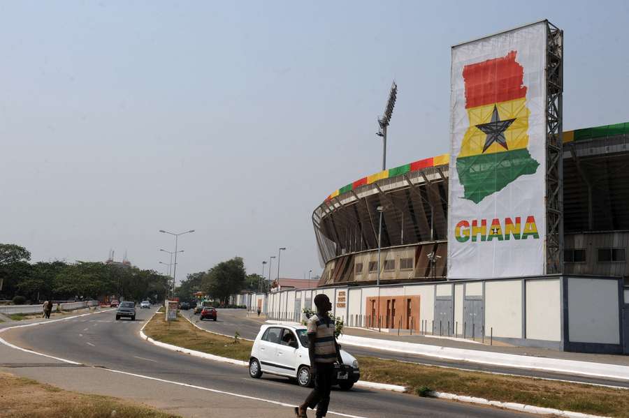 A man looks at national colours on Accra Sports Stadium