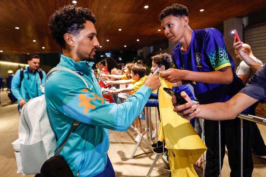 Zagueiro Marquinhos autografa camisas na chegada da Seleção