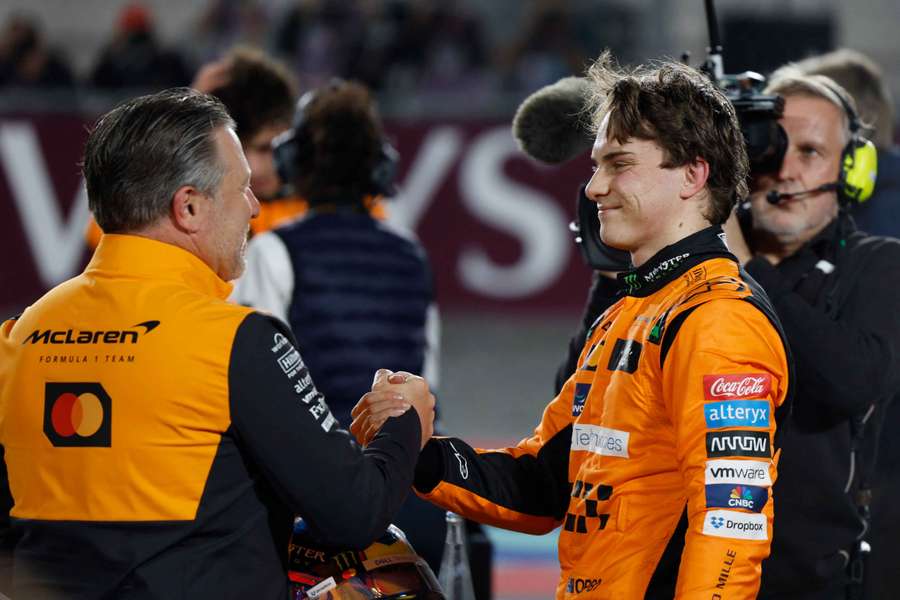Oscar Piastri sărbătorește victoria alături de Zak Brown, stânga