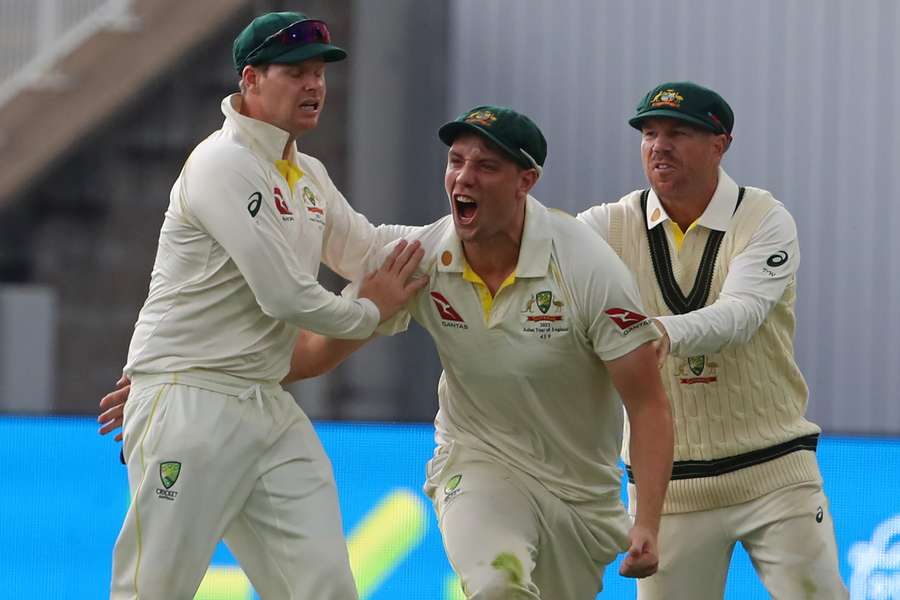 Australia's Cameron Green (C) celebrates with Australia's Steve Smith (L) and Australia's David Warner (R) after taking a catch to dismiss England's Ben Duckett