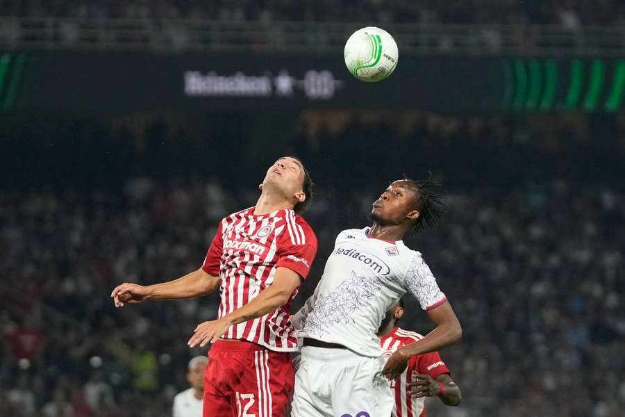 Olympiacos' Santiago Hezze (left) jumps for the ball with Fiorentina's Christian Kouame