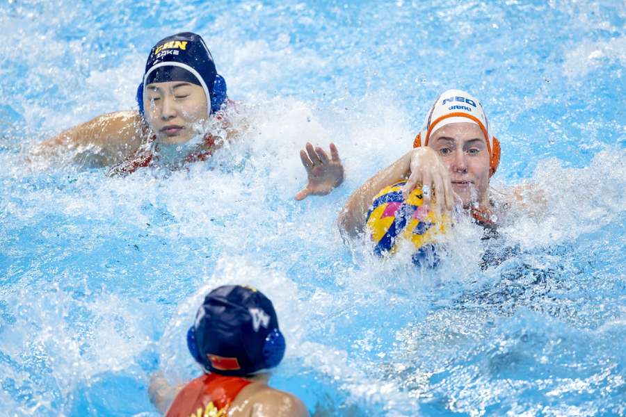 Jing Zhang en Kitty Joustra tijdens de dameswaterpolowedstrijd tussen Nederland en China op de FINA Wereldkampioenschappen zwemmen Doha 2024.