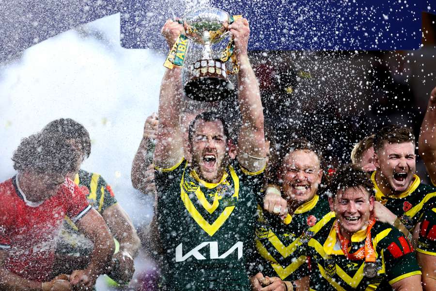 Kangaroos captain Isaah Yeo hoists the Rugby League Ashes trophy amid a shower of champagne. Kangaroos captain Isaah Yeo hoists the Rugby League Ashes trophy amid a shower of champagne.
