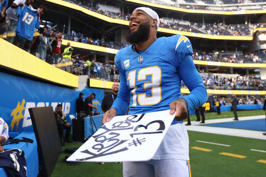 Keenan Allen reacts to a Chargers fan's sign after a game (2023)